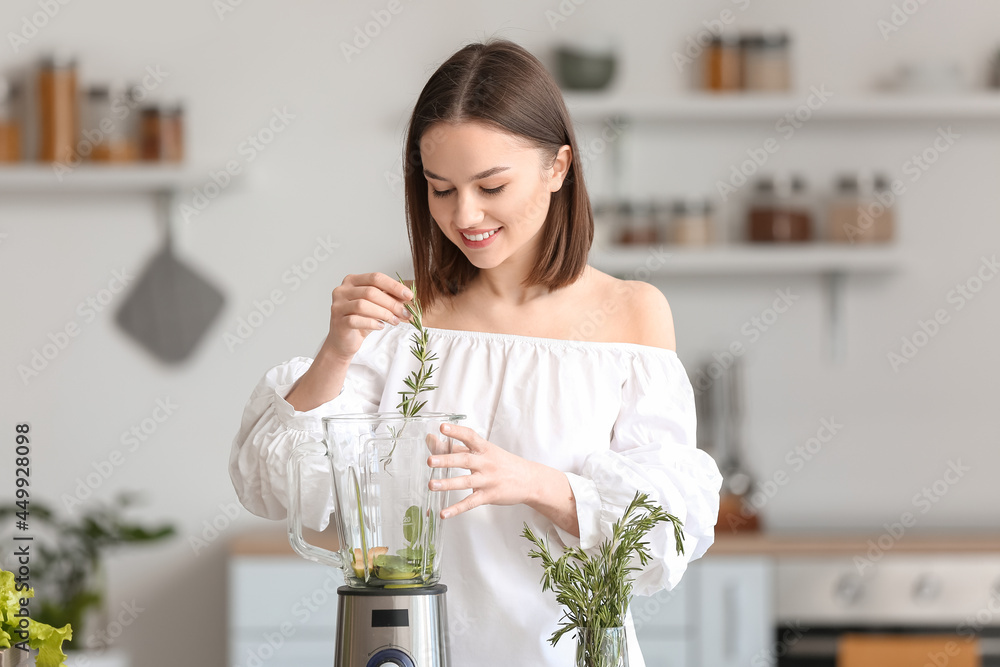 年轻女性在厨房准备健康的绿色奶昔