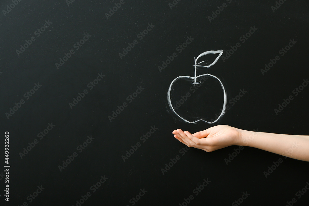 Female hand and drawn apple on dark background