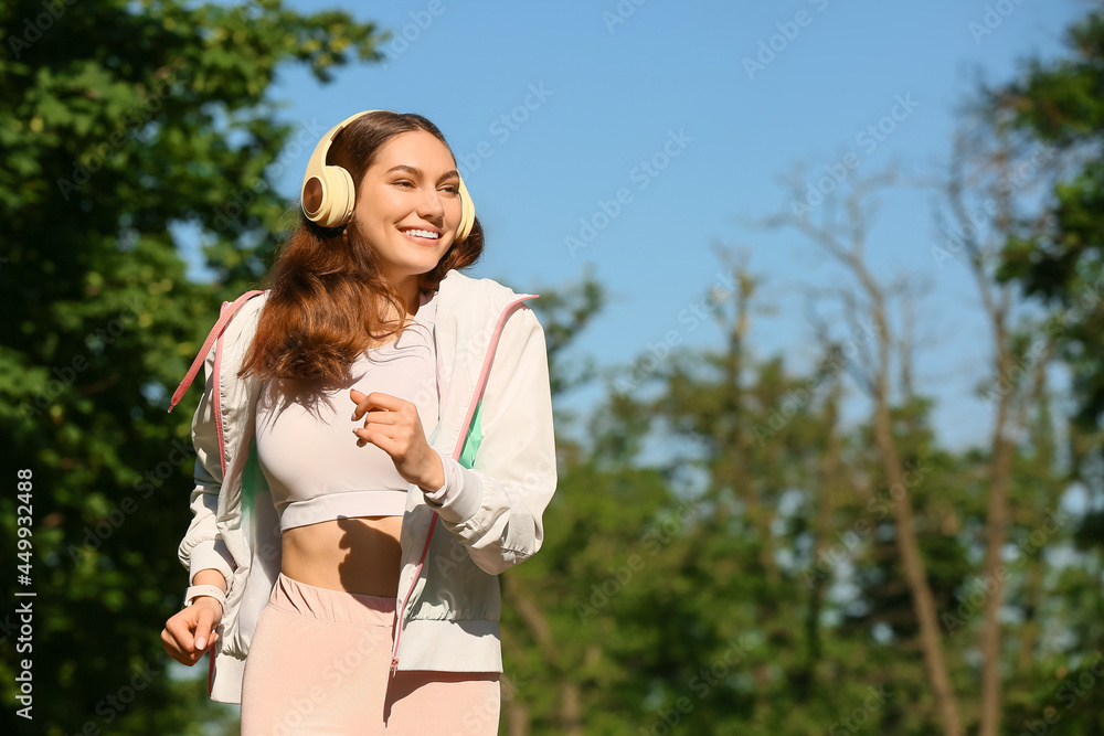 运动型年轻女性在户外跑步时听音乐