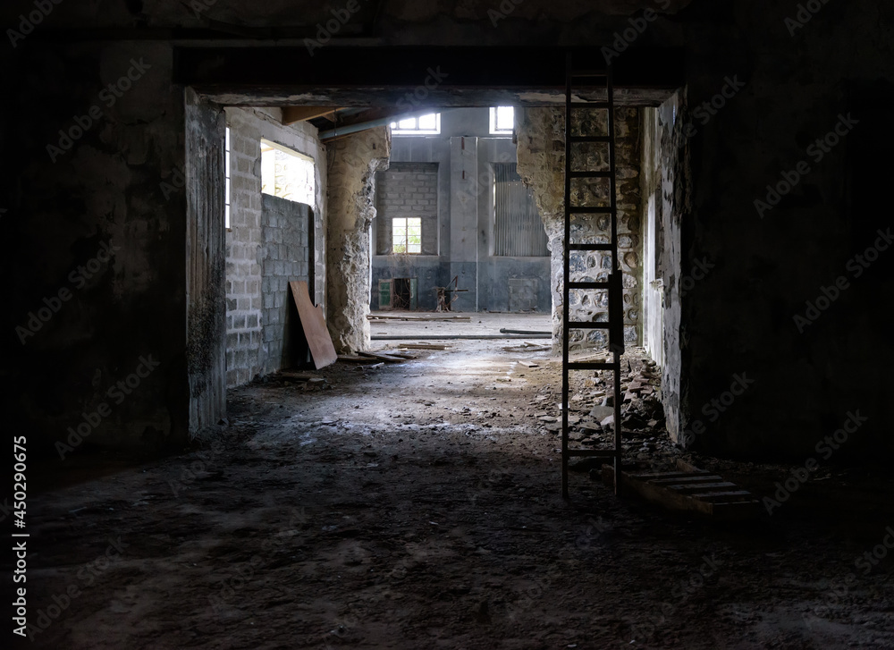 Abandoned industrial interior. Old factory with rubble on floor, broken glass and wooden stairs