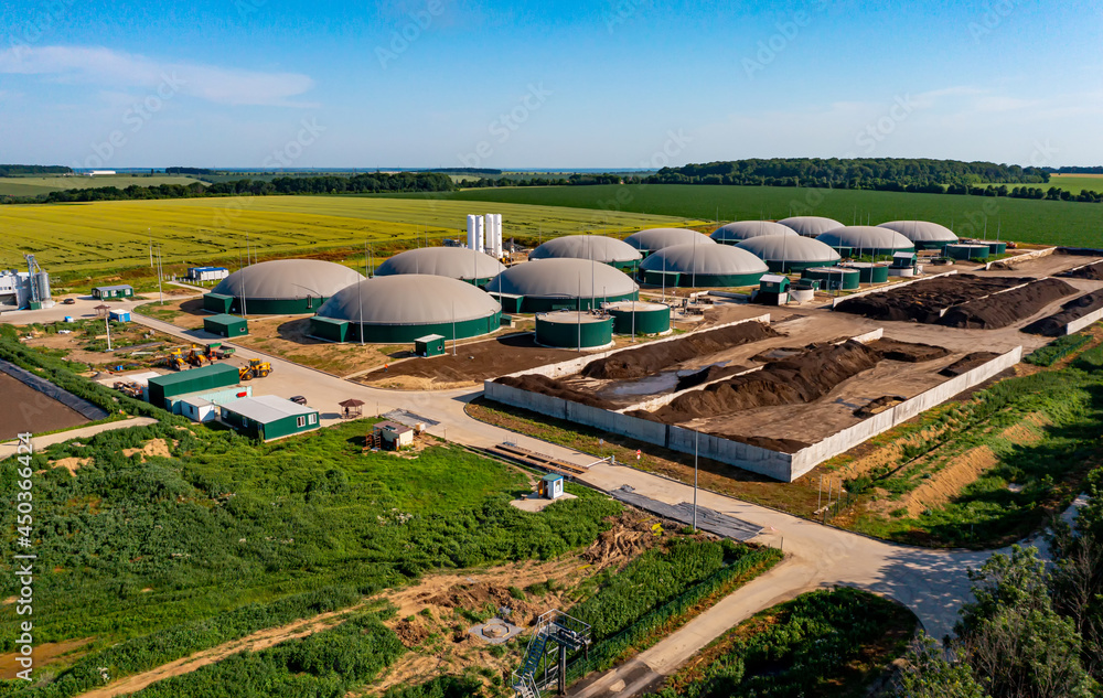 Biogas station at the green large field. Distillation process is used to produce bio gas at station.