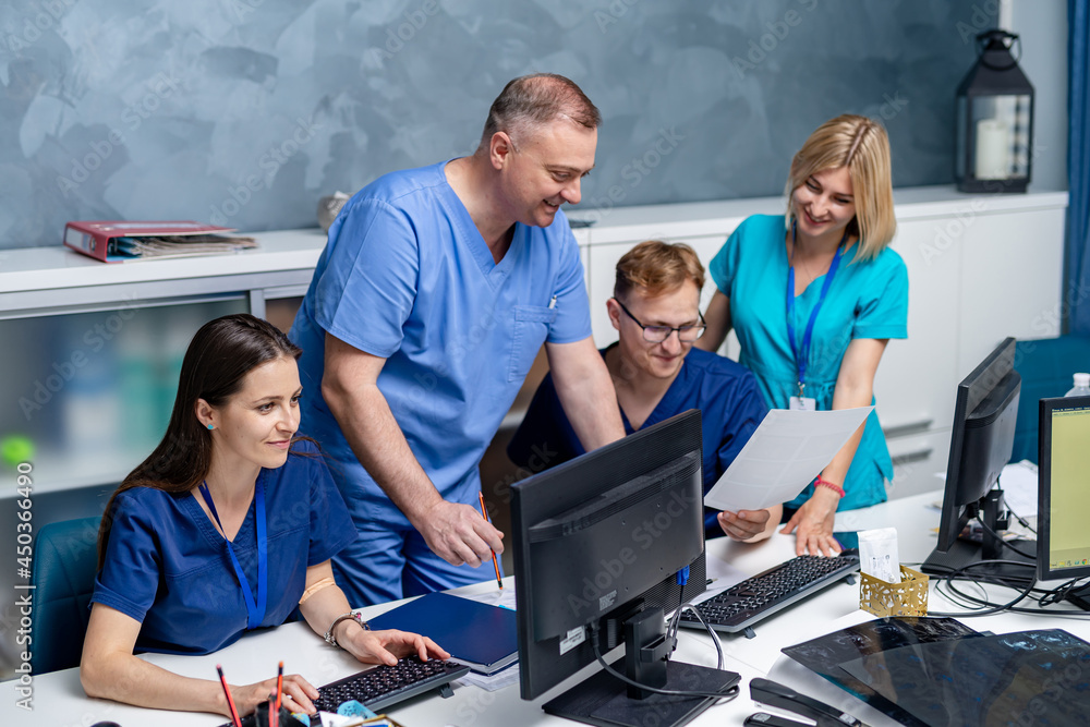 Team of doctors working in office near computer and discussing medical issues. Portrait of medical t