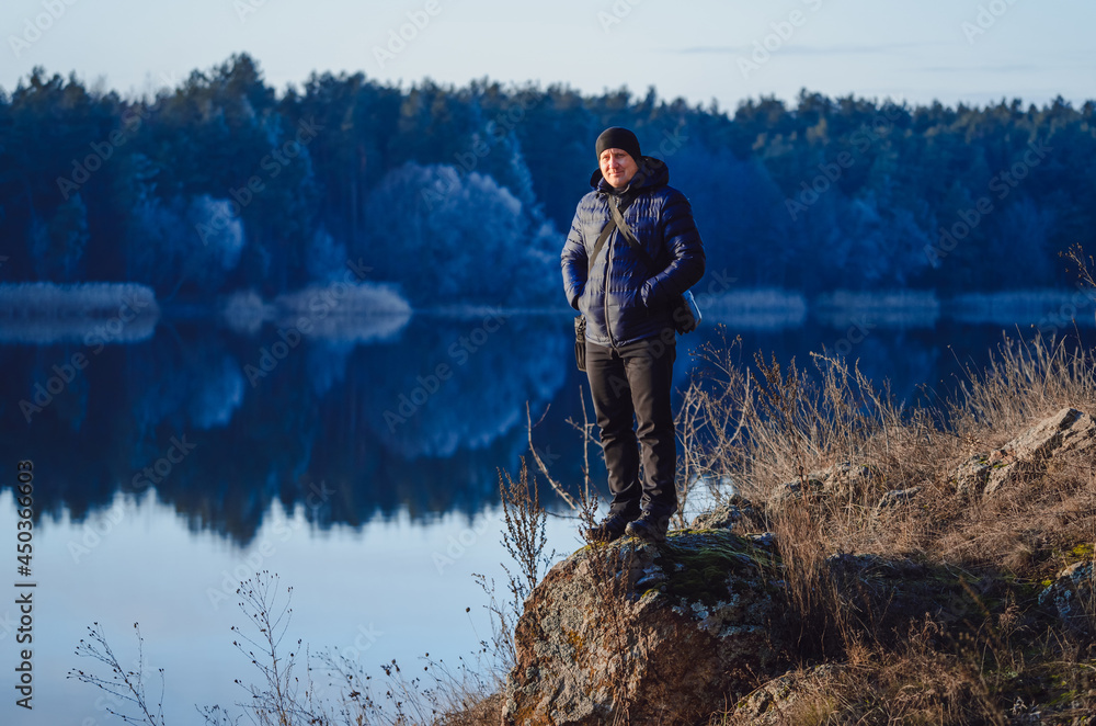 Hiker photographer preparing to taking picture of morning landscape in autumn mountains. Man looking