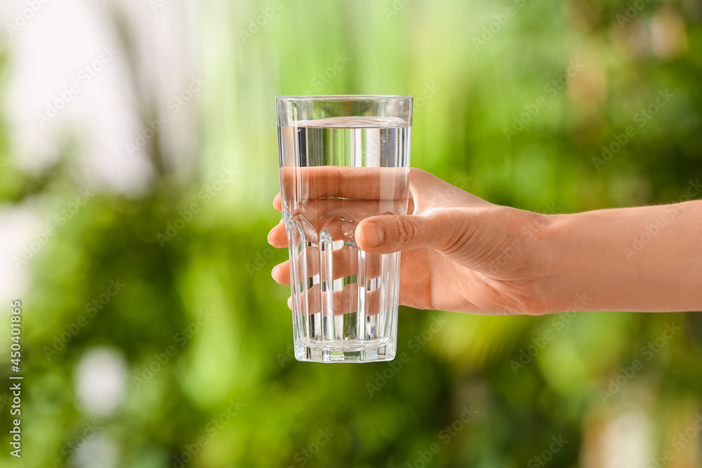 女性手拿一杯室外新鲜冷水，特写