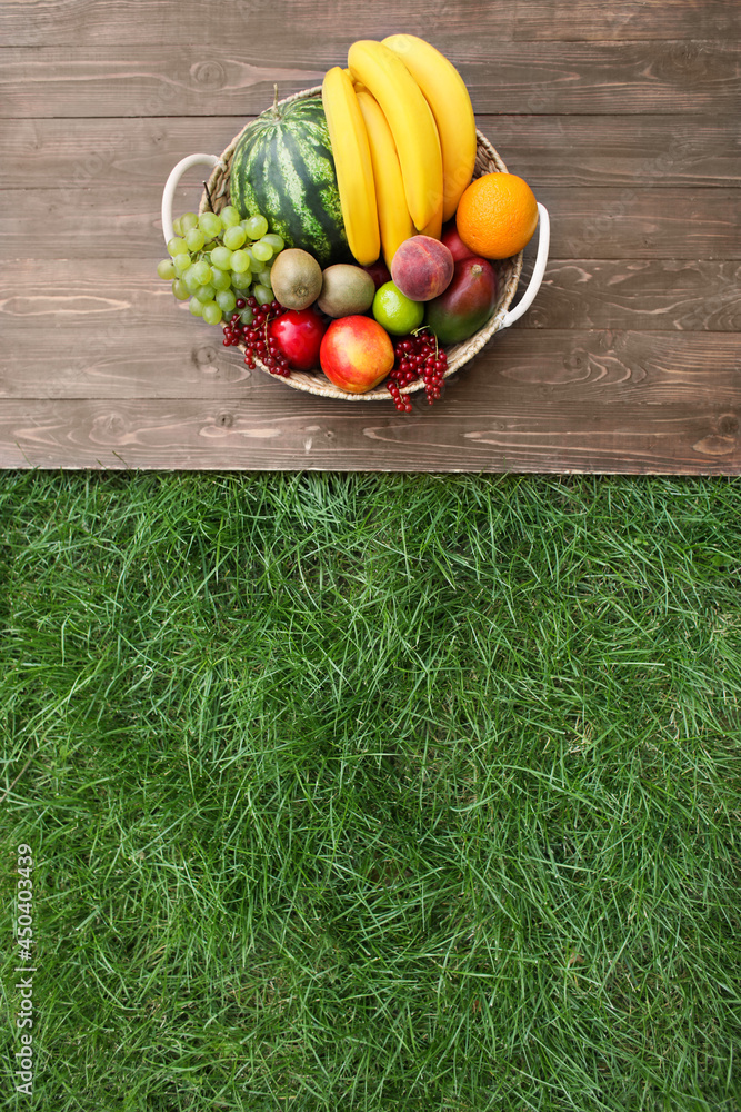 Wicker basket with fruits on table outdoors