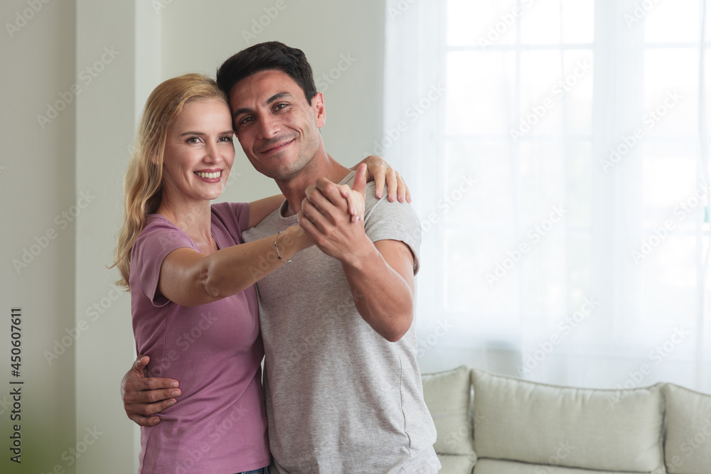 Romantic Caucasian couple dancing In the living room at home.