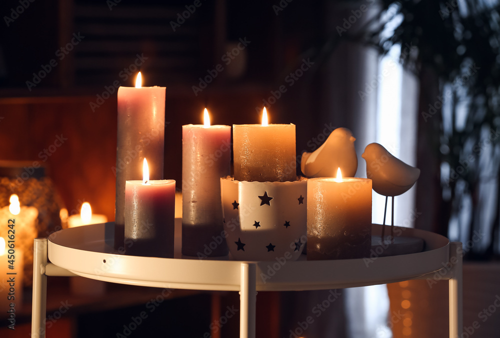 Burning candles on table in dark room