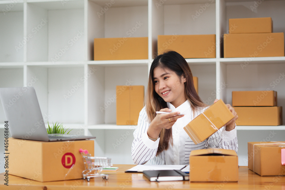 Startup small business entrepreneur SME, young asian woman working with laptop computer and delivery