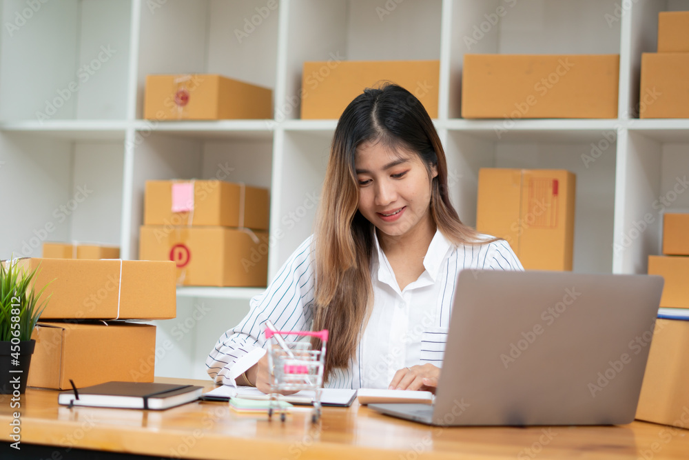 Startup small business entrepreneur SME, young asian woman working with laptop computer and delivery