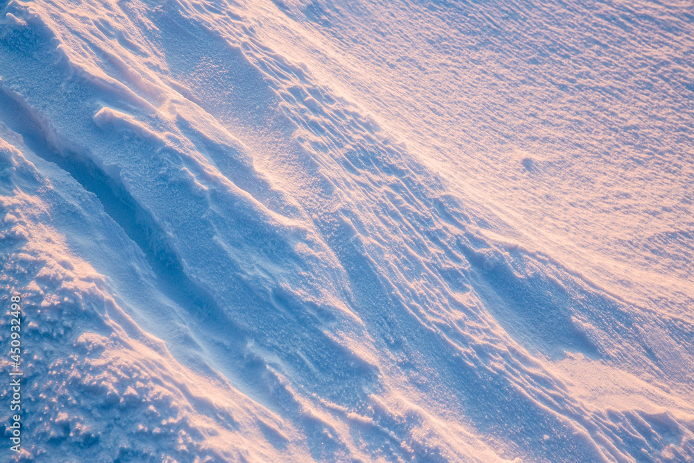 美丽的冬季背景，雪地。自然的雪纹理。风在雪上雕刻图案