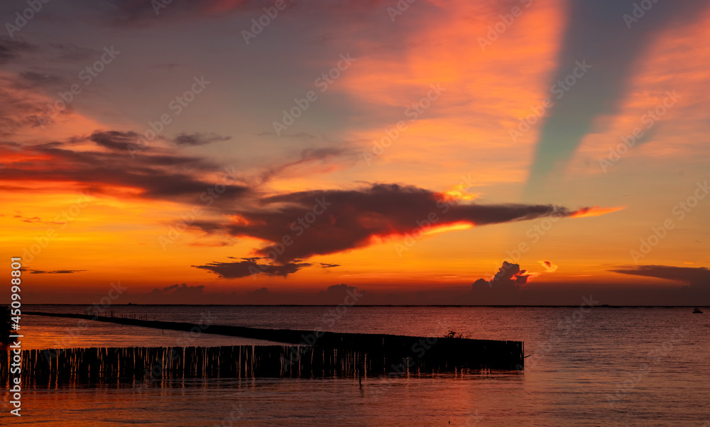 热带海洋上美丽的红色和橙色日落天空。红色日落天空。海上天际线。热带