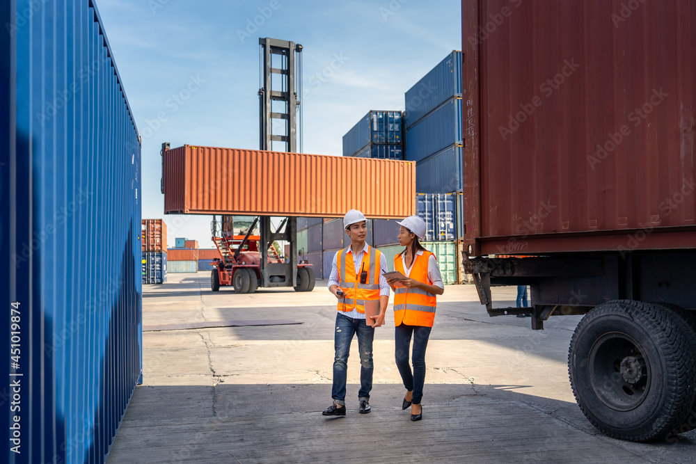 Engineers are overseeing the transportation of cargo with containers inside the warehouse. Container