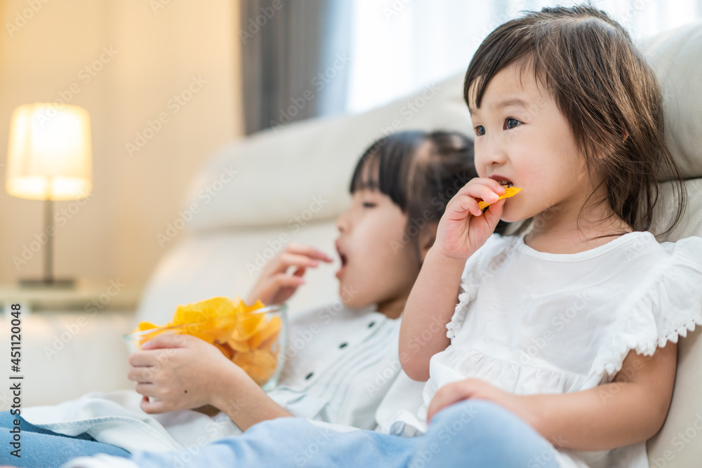 亚洲饥饿的小女孩兄弟姐妹用手把零食放进嘴里