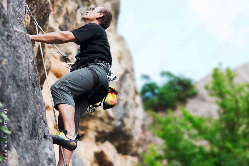 一名男子登上以天空为背景的大山