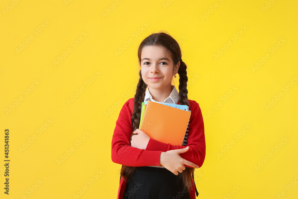 Cute little school girl on color background