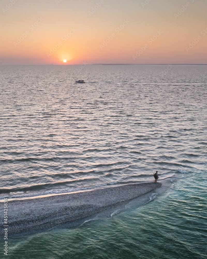 Aerial view over evening sea and spit with tourist