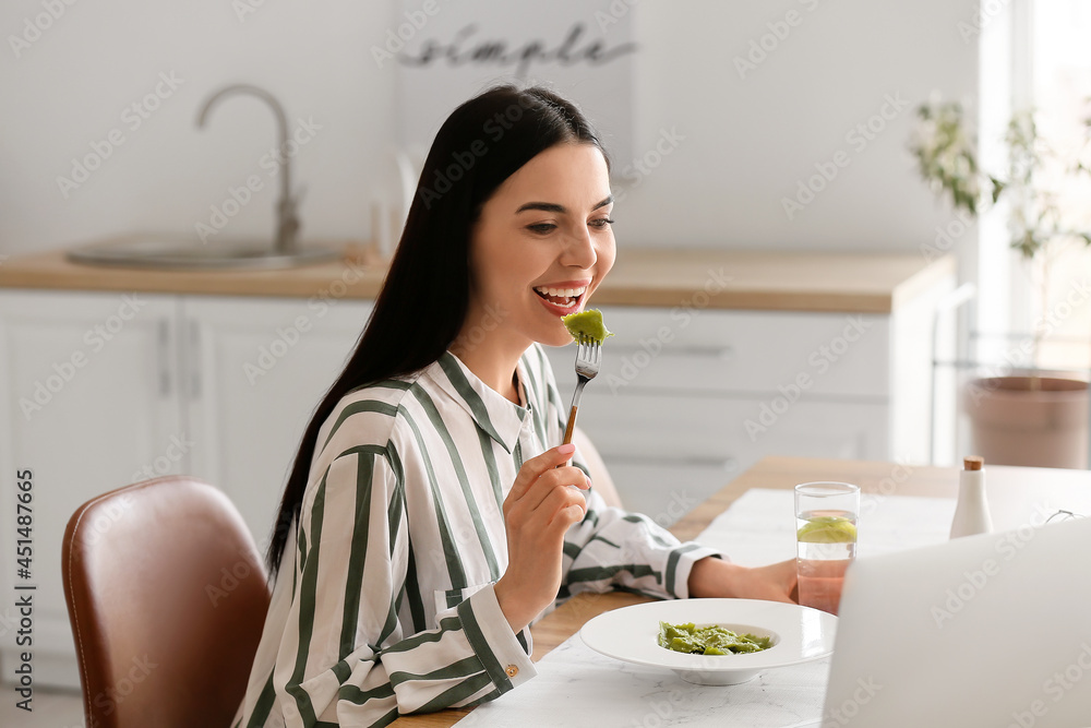 美丽的年轻女子在家吃美味的饺子