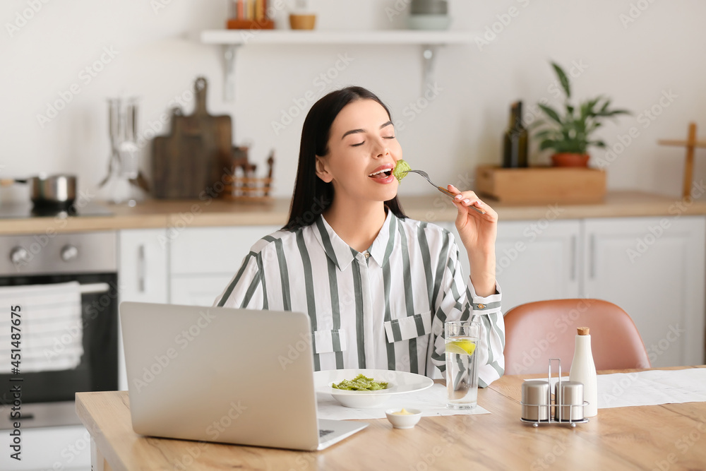 美丽的年轻女子在家吃美味的饺子