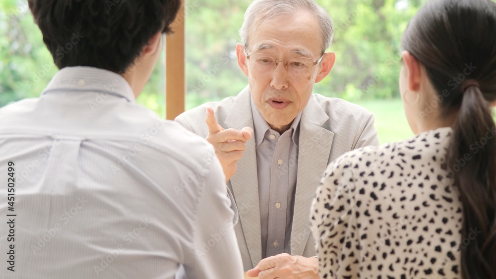 家族に説教をする高齢の男性