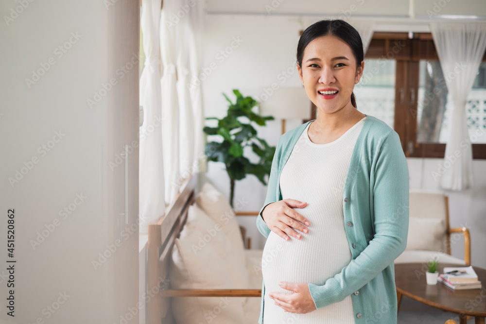 亚洲年轻孕妇在家大肚子微笑