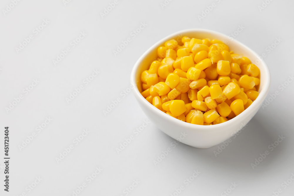 Bowl of corn kernels on white background