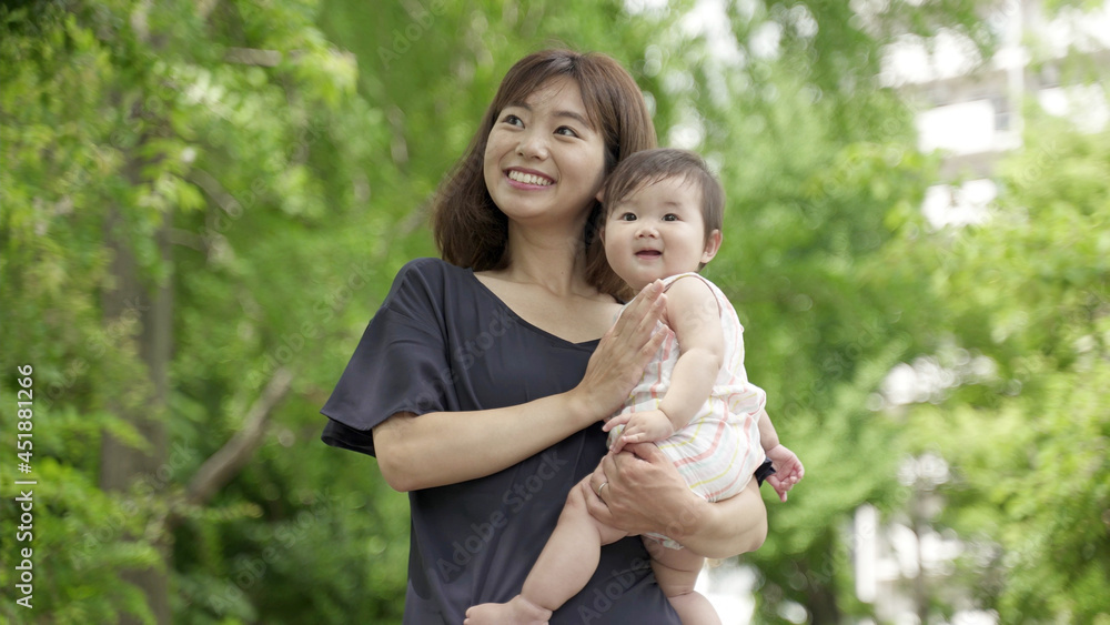 公園を散歩する赤ちゃんとお母さん