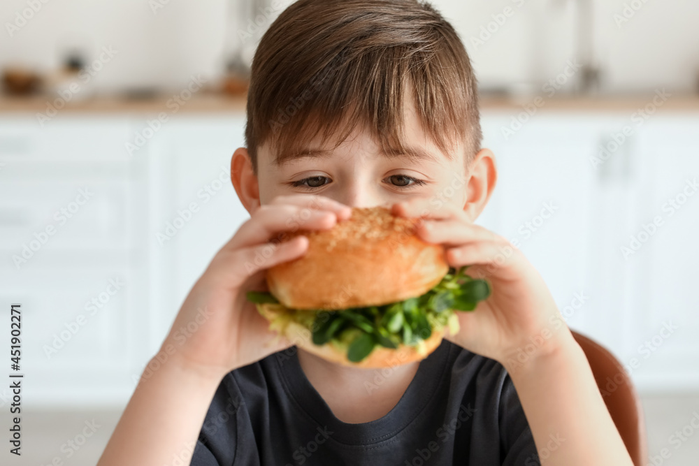 厨房里有美味素食汉堡的小男孩