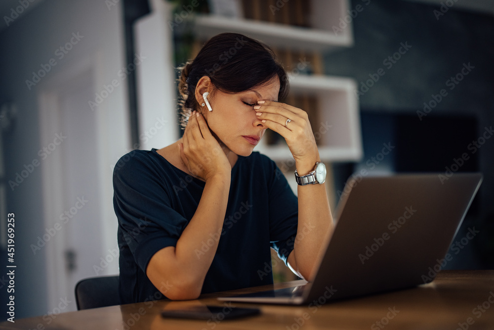 Exhausted businesswoman working late, at home.