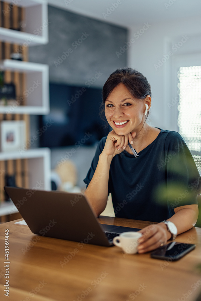 Portrait of a smiling businesswoman working in home office.