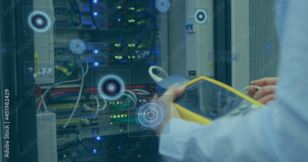 Multiple round scanners against mid section of man working in computer server room