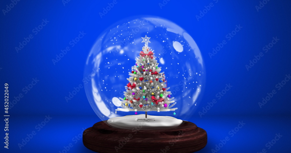 Digital image of snow falling over christmas tree in a snow globe against blue background