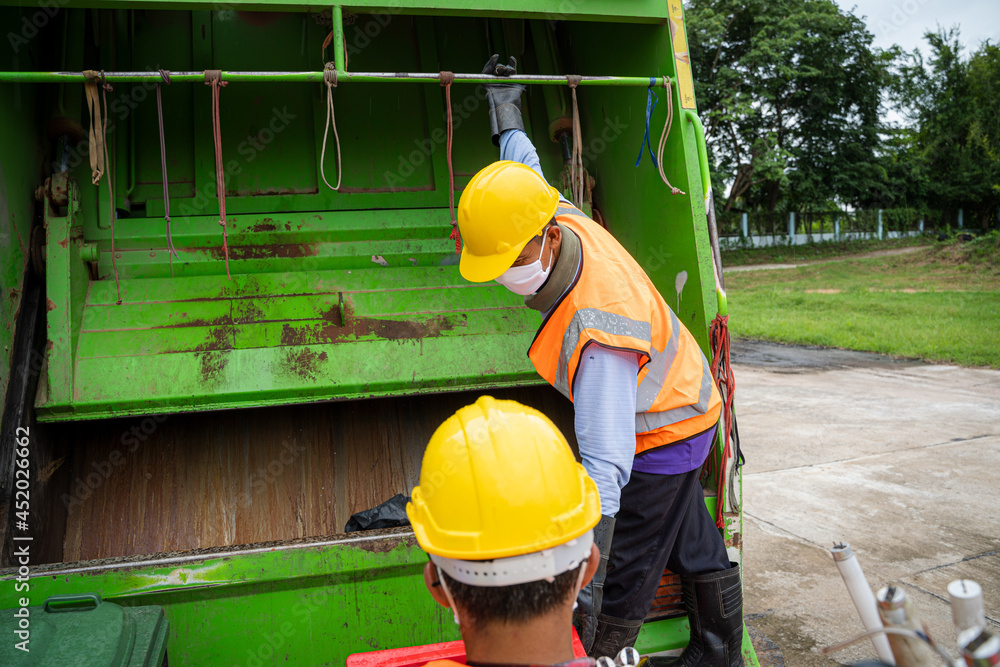 Worker of recycling garbage collector truck loading waste and trash bin,Waste collectors at work.