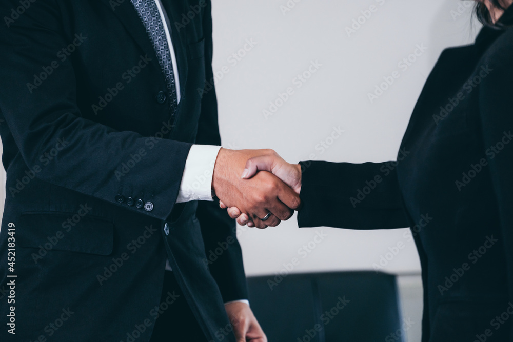 Business people agreement concept. Businessman and Asian businesswoman do handshake in the office.