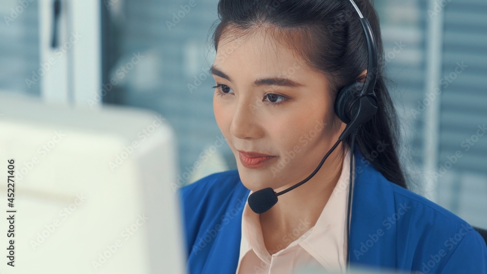 Businesswoman wearing headset working actively in office . Call center, telemarketing, customer supp