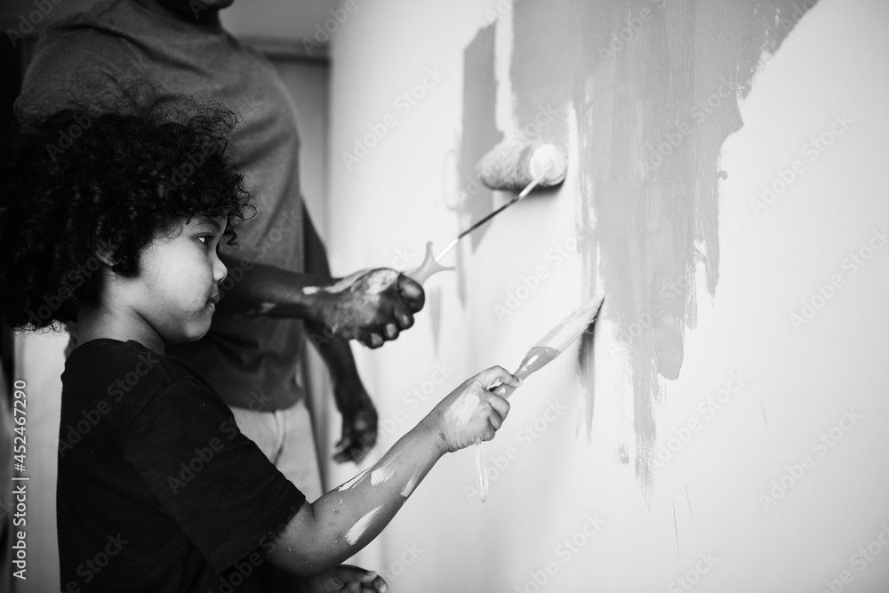 Black family painting house wall