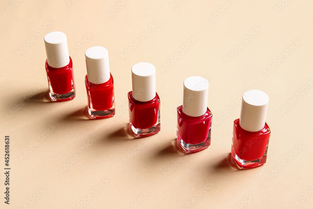 Bottles of nail polishes on color background