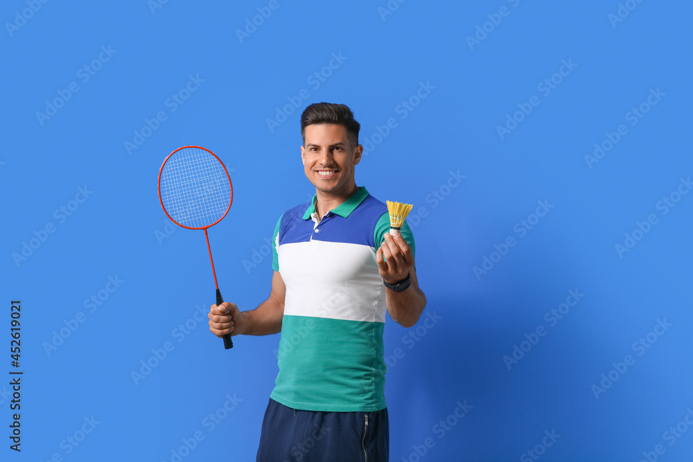 Sporty male badminton player on color background