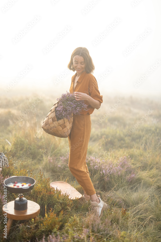 一个可爱的女人的肖像，带着刚摘下的石南花花束，穿着雾蒙蒙的衣服在山上