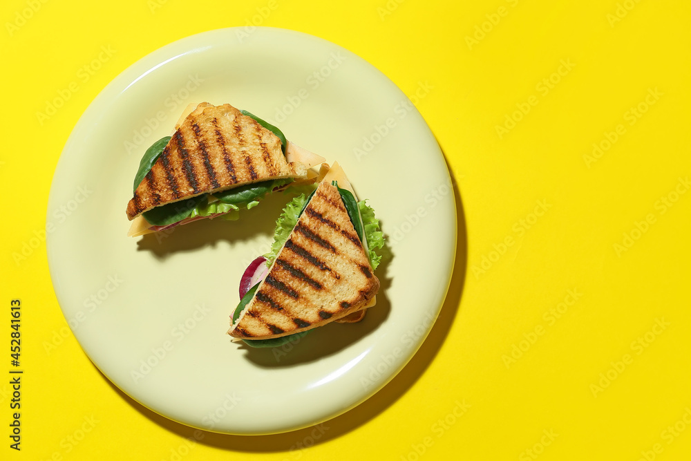 Plate with tasty sandwiches on color background