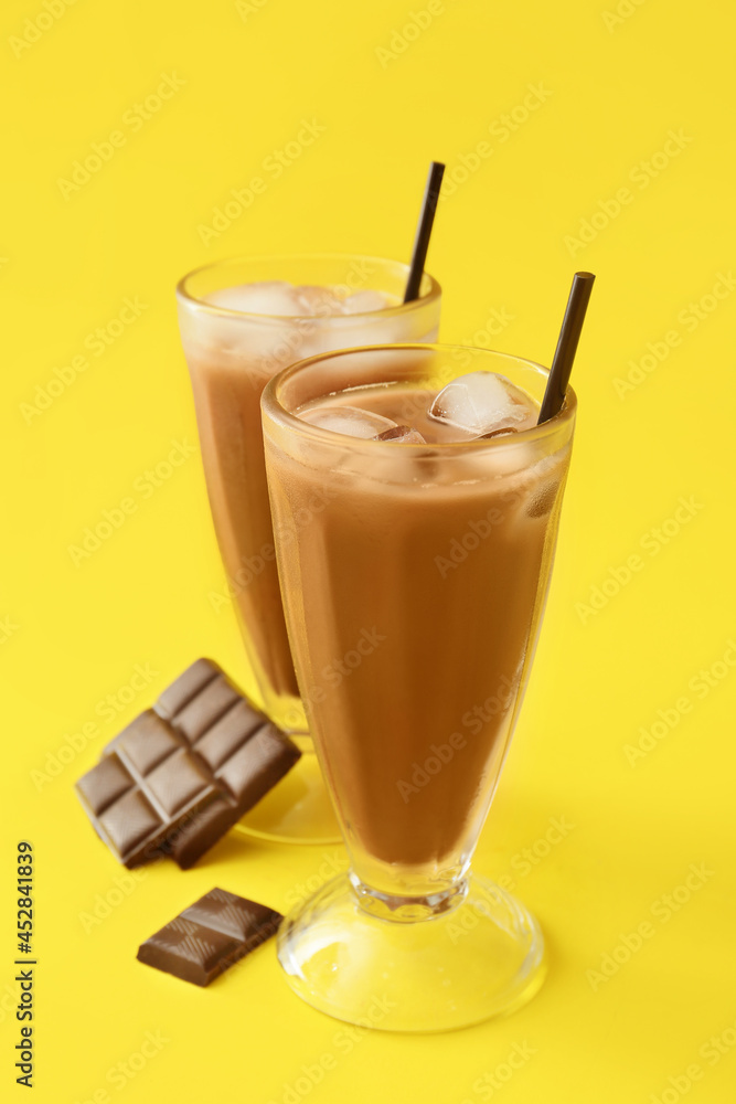 Glasses of tasty chocolate milk on color background