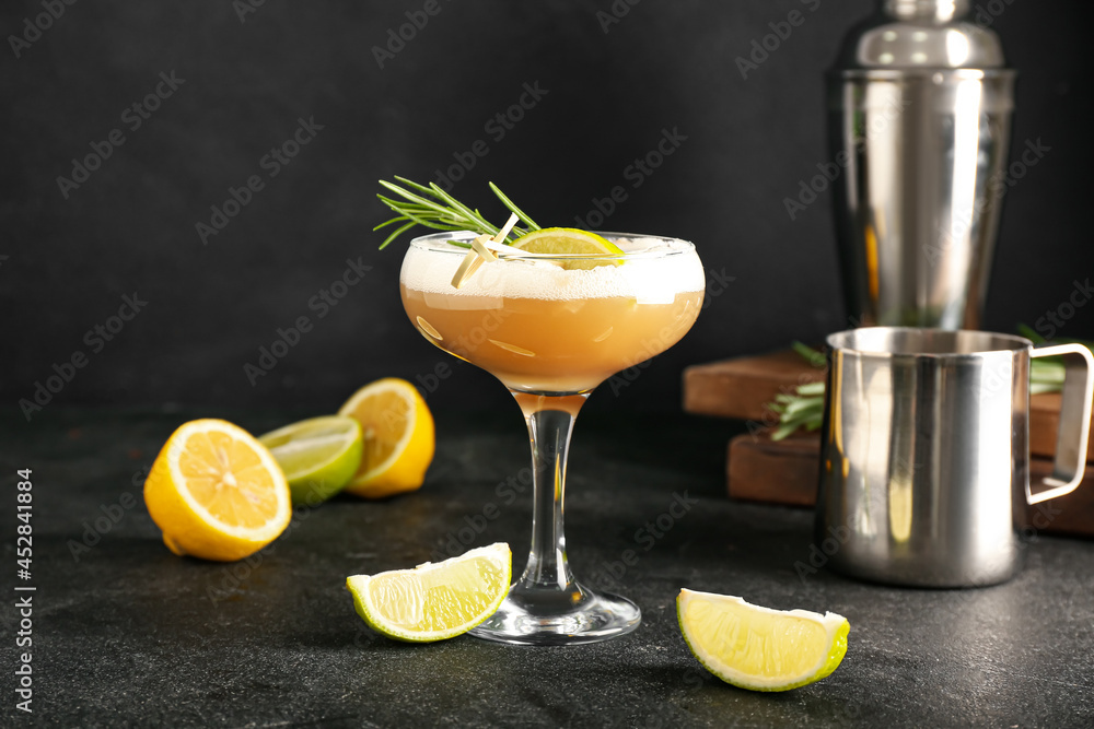 Glass of tasty whiskey sour cocktail on dark background