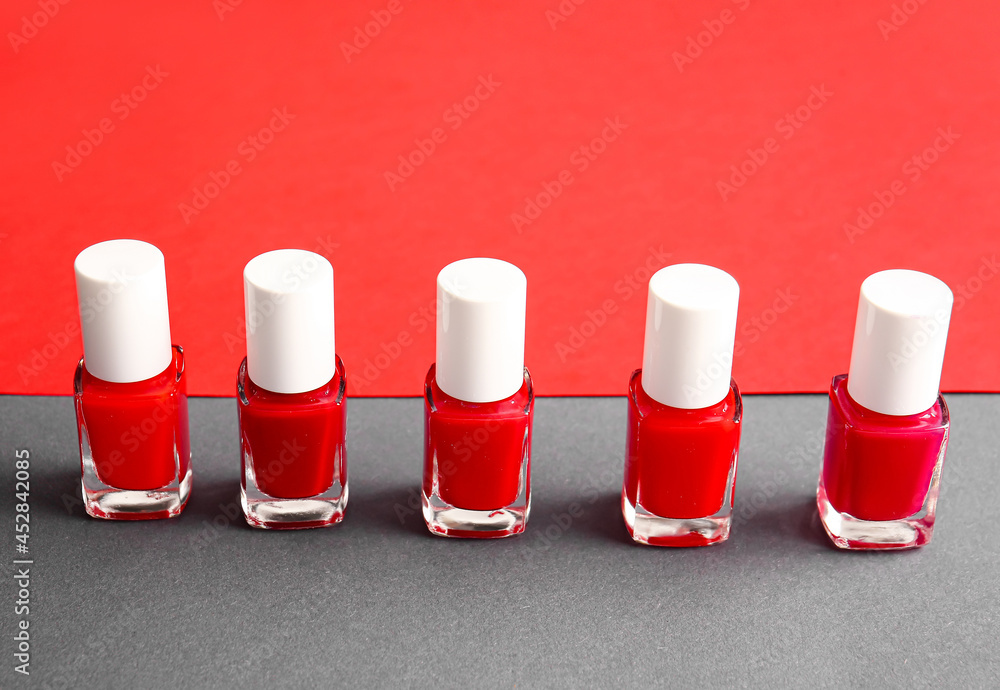 Bottles of nail polishes on color background