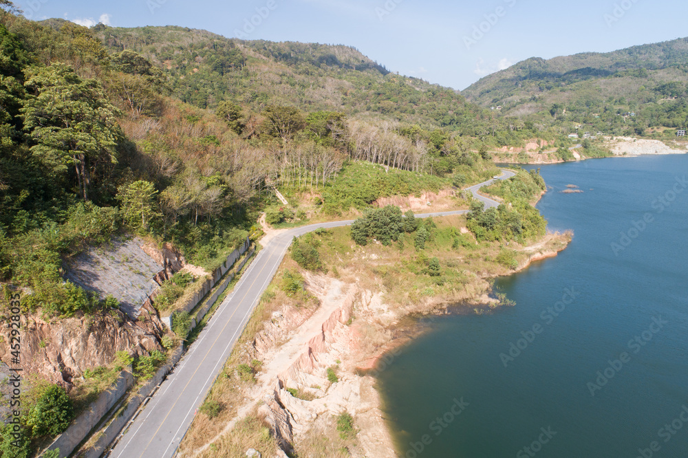 大坝湖周围的鸟瞰道路森林树木景观。