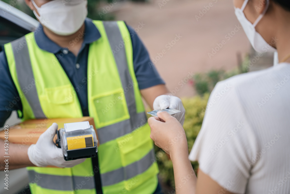 A delivery man accept credit card using a credit card reader while delivering products to customers 