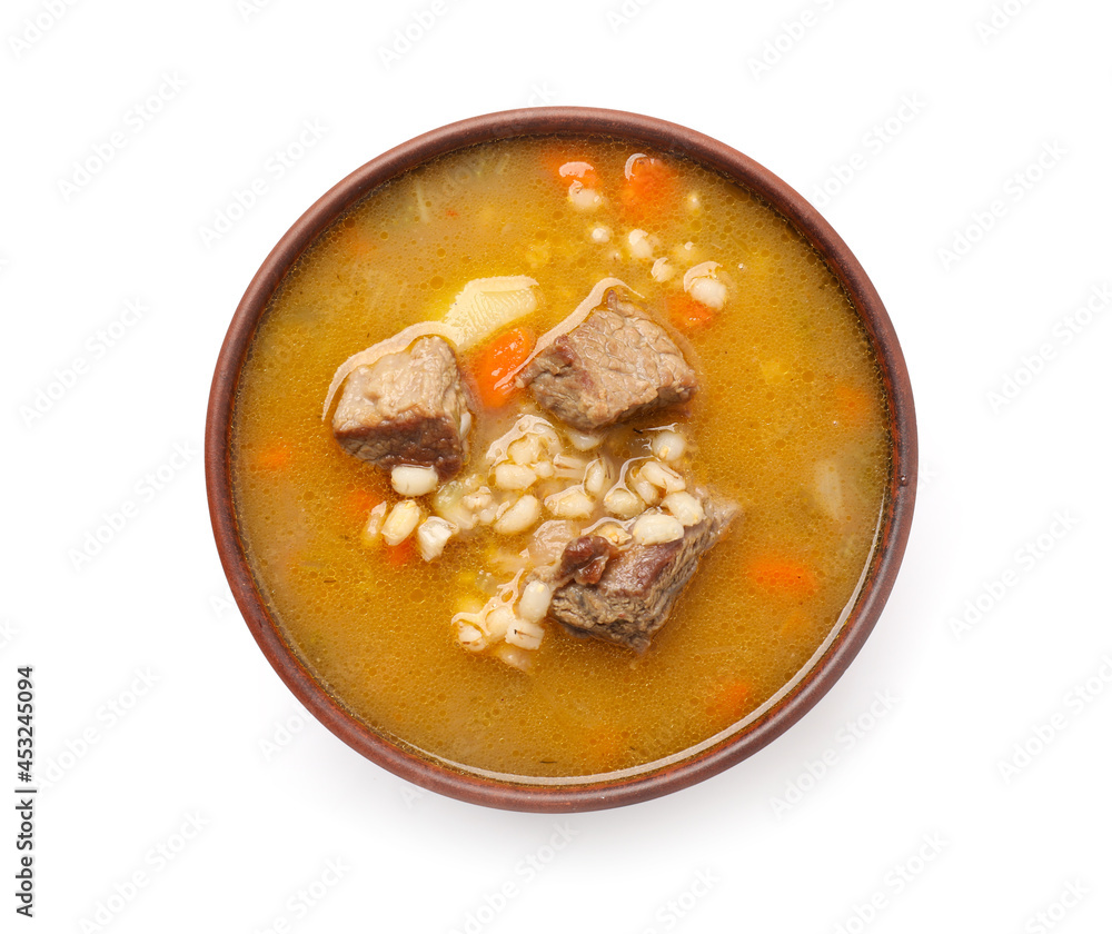 Bowl with tasty beef barley soup on white background