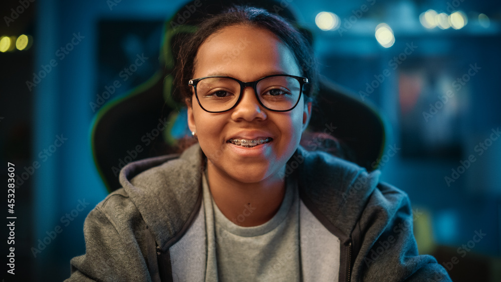 Portrait of a Cute Young Teenage Multiethnic Black Girl in a Dark Cozy Room at Home. Shes Happy, Lo