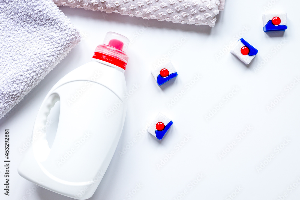 Bath towels stack with detergent bottle in laundry top view mockup