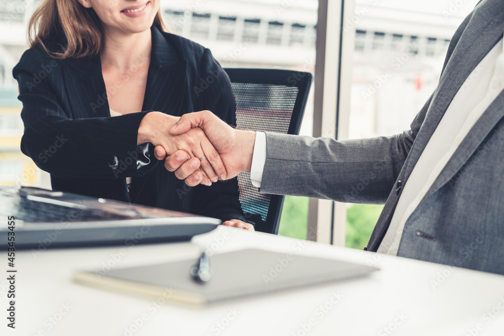 Businessman executive handshake with businesswoman worker in modern workplace office. People corpora