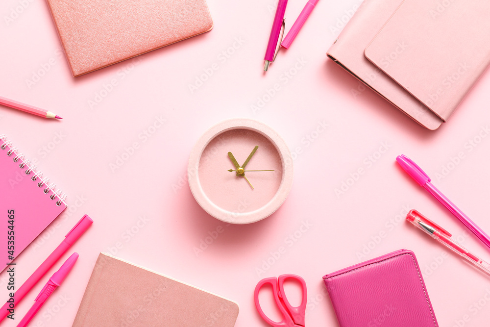 Alarm clock with office supplies on color background