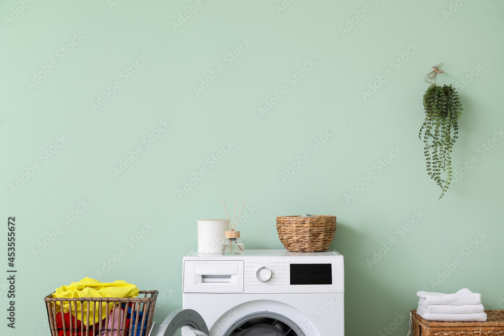 Modern washing machine with laundry in interior of bathroom